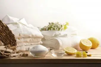 Productos de limpieza de ropa alternativos en la mesa con camisas blancas limpias