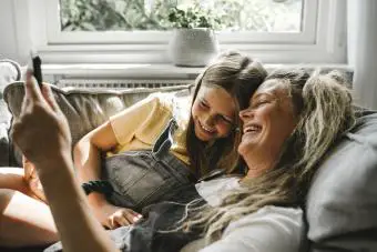 Mamá e hija riéndose en el sofá