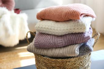 Montón de suéteres de punto de diferentes colores y patrones cuidadosamente apilados