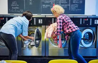 mujeres metiendo ropa en lavadoras 